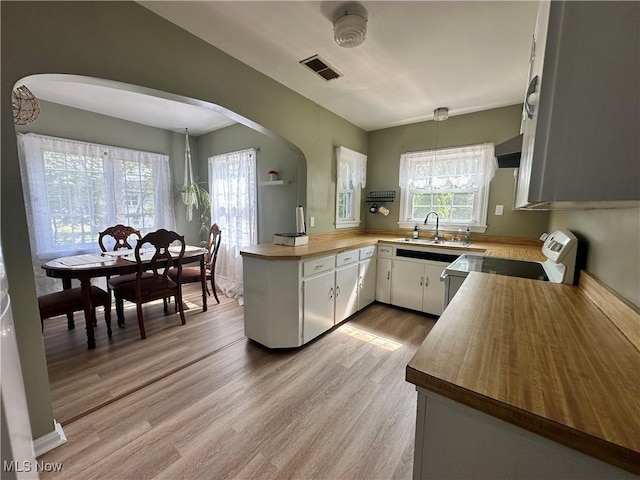 1624 Krumroy Rd, Akron, OH 44306 - kitchen with electric range, arched walkways, light wood-style flooring, wooden counters, and a peninsula