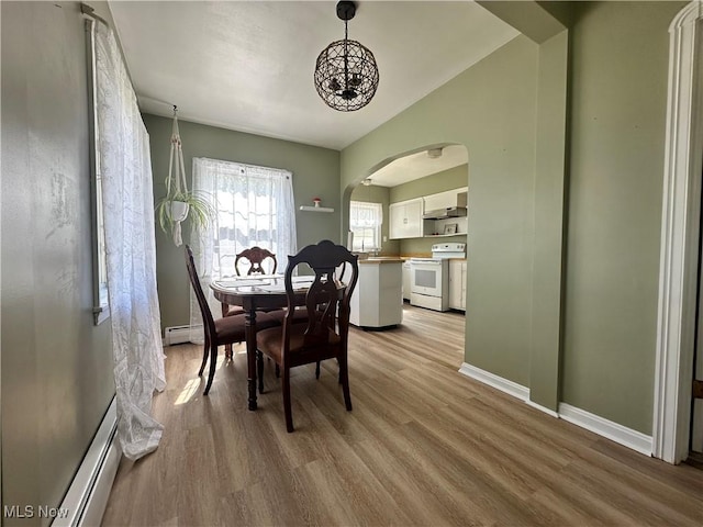 1624 Krumroy Rd, Akron, OH 44306 - dining space featuring arched walkways, wood finished floors, and a baseboard radiator