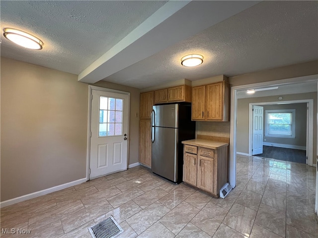 1365 Craneing Rd, Wickliffe, OH 44092 - kitchen with freestanding refrigerator, a textured ceiling, light countertops, and brown cabinetry