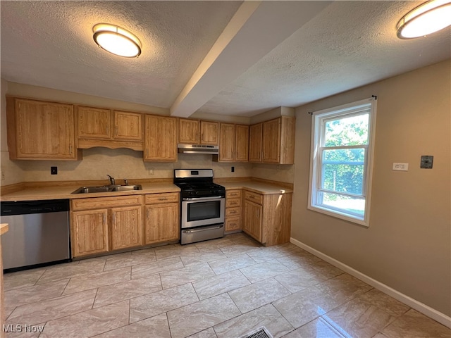 1365 Craneing Rd, Wickliffe, OH 44092 - kitchen with appliances with stainless steel finishes, under cabinet range hood, a textured ceiling, light countertops, and light stone finish flooring