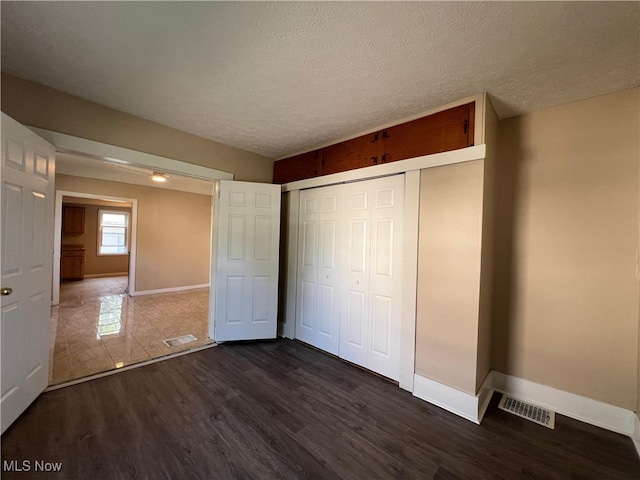 1365 Craneing Rd, Wickliffe, OH 44092 - unfurnished bedroom featuring dark wood-style floors, a closet, and a textured ceiling