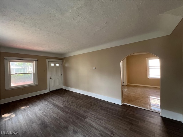 1365 Craneing Rd, Wickliffe, OH 44092 - entrance foyer featuring arched walkways, a textured ceiling, and dark wood-style floors
