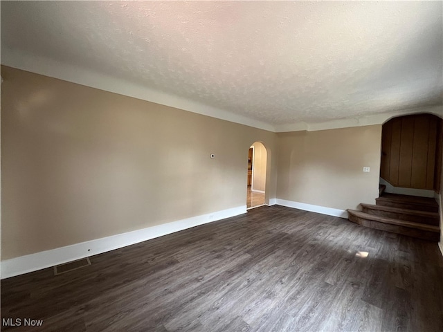 1365 Craneing Rd, Wickliffe, OH 44092 - unfurnished room featuring arched walkways, a textured ceiling, dark wood-style floors, and stairway