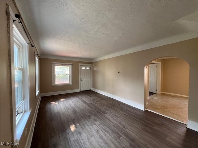1365 Craneing Rd, Wickliffe, OH 44092 - empty room with a textured ceiling, arched walkways, and dark wood-type flooring
