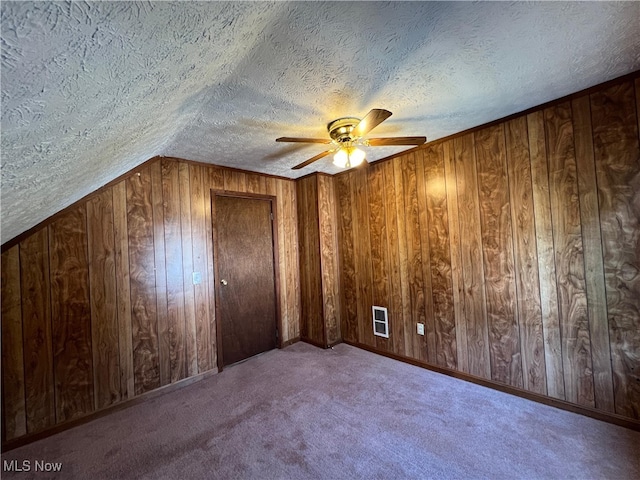 1365 Craneing Rd, Wickliffe, OH 44092 - additional living space with a textured ceiling, a ceiling fan, wooden walls, and carpet flooring