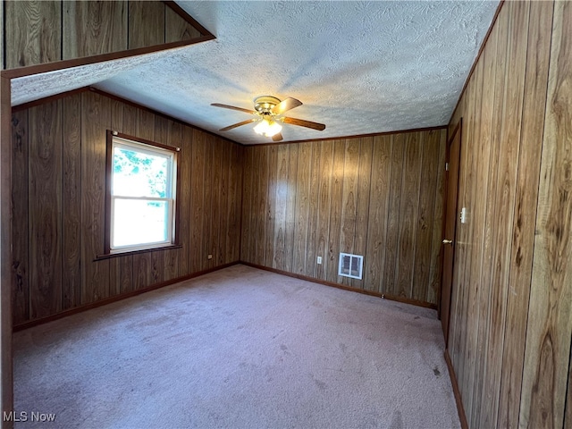 1365 Craneing Rd, Wickliffe, OH 44092 - unfurnished room featuring a textured ceiling, ceiling fan, light carpet, and wood walls