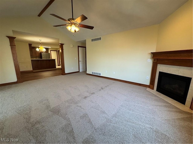 1204 Saint Abigail St SW, Hartville, OH 44632 - unfurnished living room featuring a tiled fireplace, a ceiling fan, carpet floors, beamed ceiling, and high vaulted ceiling