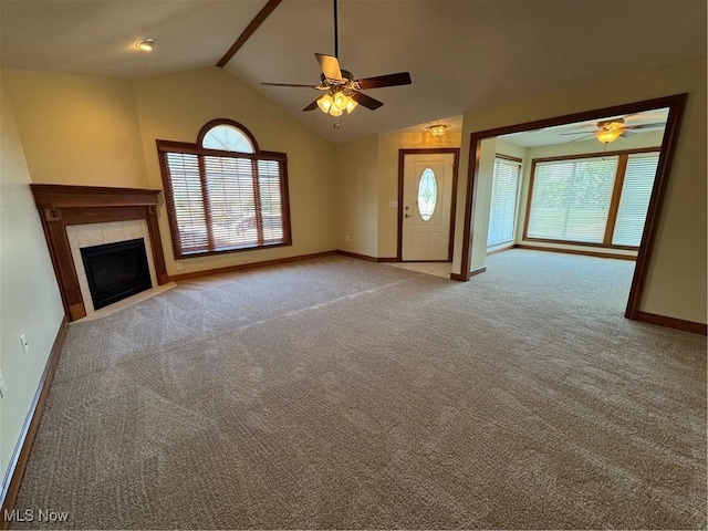 1204 Saint Abigail St SW, Hartville, OH 44632 - unfurnished living room featuring a ceiling fan, lofted ceiling, carpet flooring, and a tiled fireplace