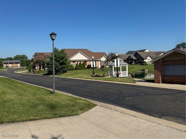 1204 Saint Abigail St SW, Hartville, OH 44632 - view of asphalt road featuring street lighting, a residential view, and curbs
