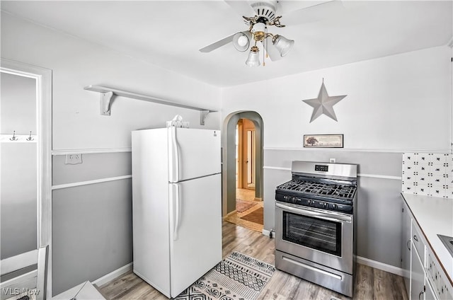 474 W 4th St, Salem, OH 44460 - kitchen with freestanding refrigerator, stainless steel gas stove, arched walkways, ceiling fan, and light wood finished floors