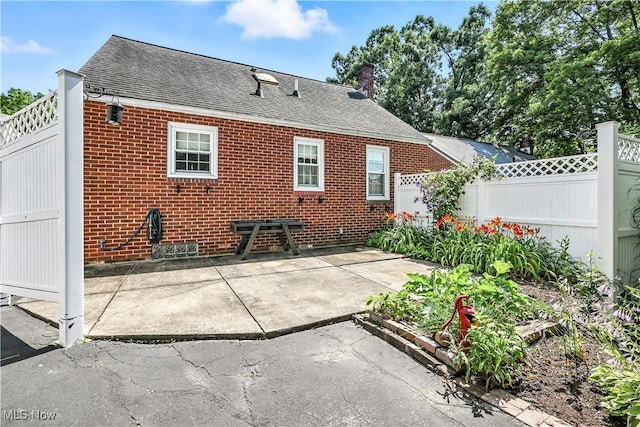 474 W 4th St, Salem, OH 44460 - back of house with a shingled roof, a patio, brick siding, and a chimney