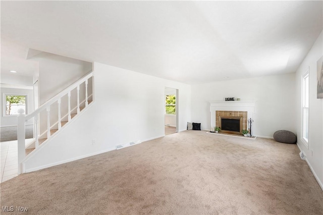 12366 Springwater Ave NW, Uniontown, OH 44685 - unfurnished living room featuring stairs, carpet floors, and a tile fireplace
