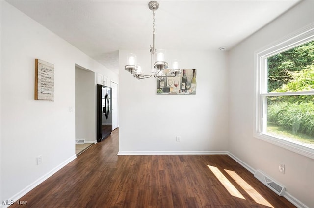 12366 Springwater Ave NW, Uniontown, OH 44685 - empty room featuring a chandelier, healthy amount of natural light, and dark wood-style flooring