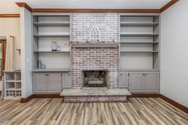 1096 Colegate Dr, Marietta, OH 45750 - unfurnished living room with wood finished floors, a brick fireplace, built in features, and ornamental molding