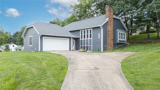 1096 Colegate Dr, Marietta, OH 45750 - split level home with an attached garage, a chimney, driveway, and a front lawn
