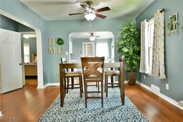 364 Meadowbrook Ave SE, Warren, OH 44483 - dining room with arched walkways, ceiling fan, and wood finished floors