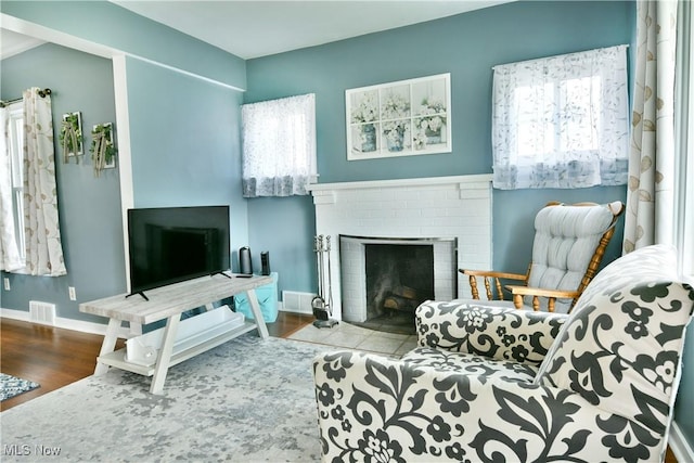 364 Meadowbrook Ave SE, Warren, OH 44483 - living room featuring healthy amount of natural light, a brick fireplace, and wood finished floors