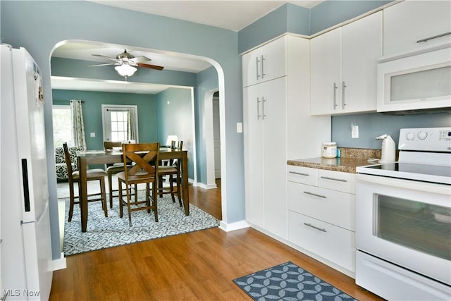 364 Meadowbrook Ave SE, Warren, OH 44483 - kitchen featuring white appliances, arched walkways, light wood-style floors, and white cabinetry
