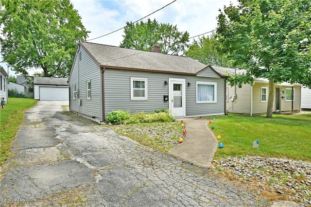 33 Mcdonald Ave, Niles, OH 44446 - view of front facade with a chimney, an outdoor structure, a front yard, and a shingled roof