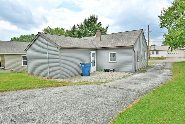 33 Mcdonald Ave, Niles, OH 44446 - rear view of house with roof with shingles, a chimney, and a yard