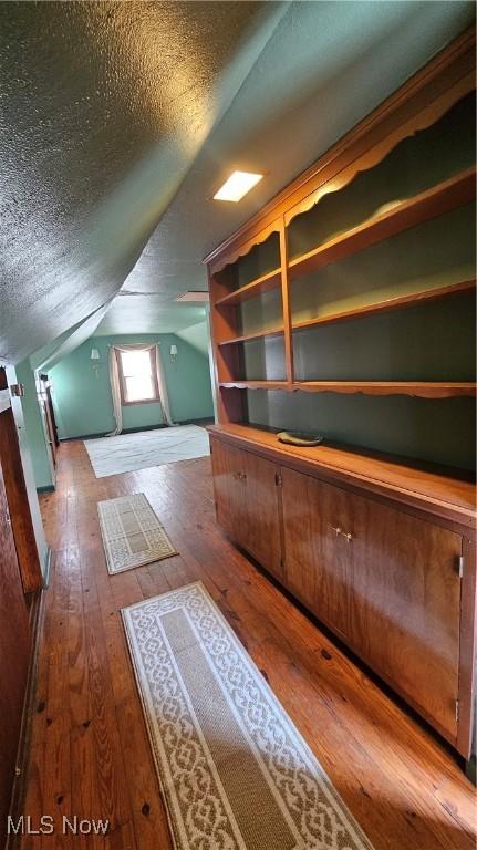 25801 Zeman Ave, Euclid, OH 44132 - additional living space featuring wood-type flooring, a textured ceiling, and vaulted ceiling
