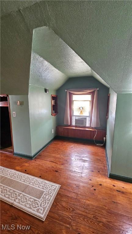 25801 Zeman Ave, Euclid, OH 44132 - additional living space featuring a textured ceiling, cooling unit, wood finished floors, and lofted ceiling