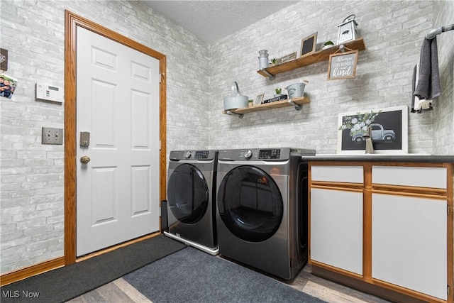 2785 Chalford Cir NW, North Canton, OH 44720 - laundry room featuring washer and dryer, cabinet space, and a textured ceiling