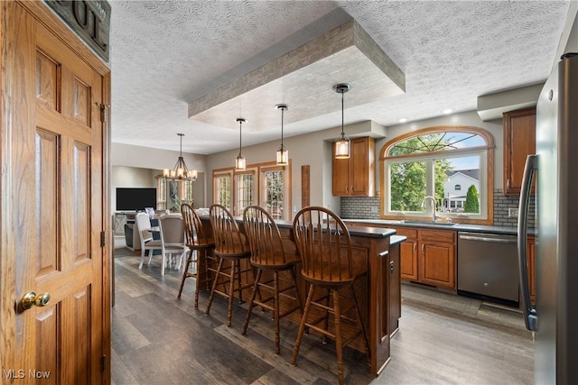 2785 Chalford Cir NW, North Canton, OH 44720 - kitchen with stainless steel appliances, a breakfast bar, wood finished floors, tasteful backsplash, and a textured ceiling