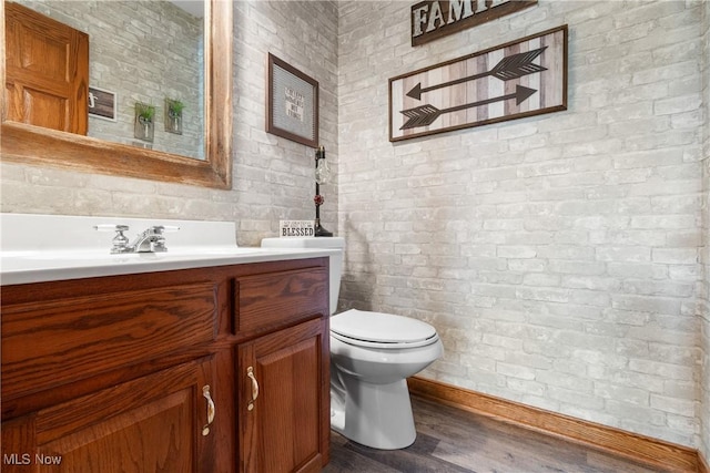 2785 Chalford Cir NW, North Canton, OH 44720 - bathroom featuring vanity, brick wall, and wood finished floors
