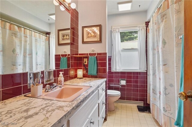 593 Mardon Ave, Akron, OH 44303 - full bathroom with tile walls, tile patterned flooring, vanity, a shower with curtain, and wainscoting