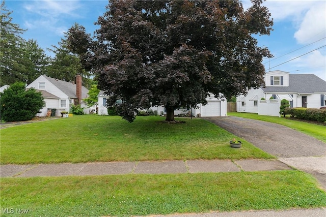 4221 2nd St NW, Canton, OH 44708 - view of front of house featuring asphalt driveway, a garage, and a front lawn