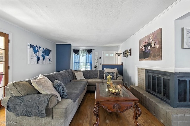 4221 2nd St NW, Canton, OH 44708 - living room with a textured ceiling, wood finished floors, a brick fireplace, and ornamental molding