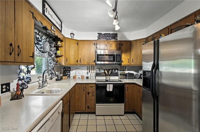 4221 2nd St NW, Canton, OH 44708 - kitchen featuring appliances with stainless steel finishes, brown cabinets, light countertops, light tile patterned flooring, and a textured ceiling