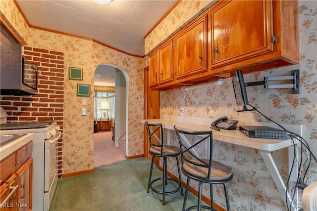 409 Yager Rd, New Franklin, OH 44216 - kitchen with white range, arched walkways, brown cabinetry, wallpapered walls, and crown molding