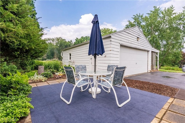 409 Yager Rd, New Franklin, OH 44216 - view of patio / terrace with a garage, outdoor dining space, and an outdoor structure