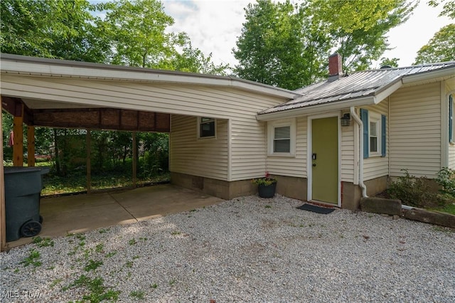 188 Stratford Ave, Wadsworth, OH 44281 - view of front of house with gravel driveway, a metal roof, an attached carport, and a chimney