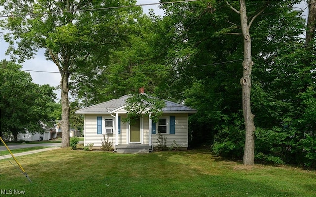 188 Stratford Ave, Wadsworth, OH 44281 - bungalow featuring a front yard, a metal roof, a standing seam roof, and a chimney