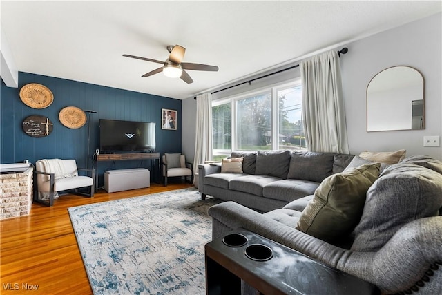 1103 Clinton Ave SE, North Canton, OH 44720 - living room featuring a ceiling fan, an accent wall, and wood finished floors