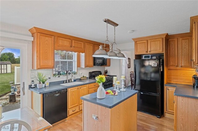 136 Westchester Dr, Brunswick, OH 44212 - kitchen with black appliances, dark countertops, light wood-style floors, and a center island