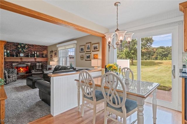 136 Westchester Dr, Brunswick, OH 44212 - dining room with a chandelier, light wood finished floors, beamed ceiling, and a fireplace