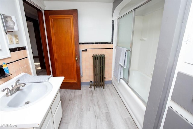 1299 Herberich Ave, Akron, OH 44301 - bathroom with radiator heating unit, tile walls, vanity, wood finished floors, and a wainscoted wall