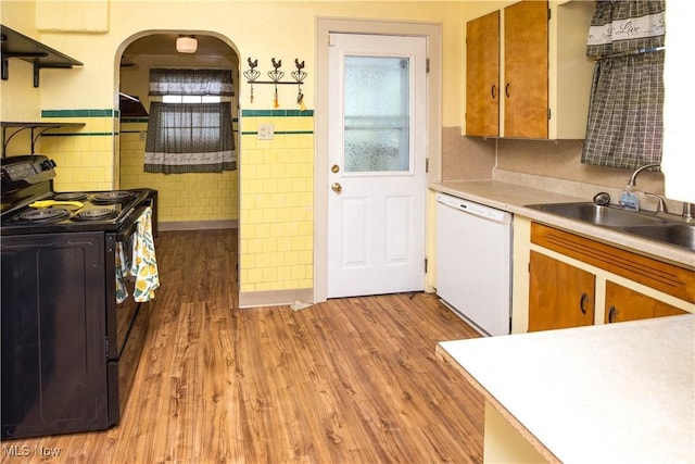 1299 Herberich Ave, Akron, OH 44301 - kitchen with black electric range oven, dishwasher, under cabinet range hood, tile walls, and light countertops