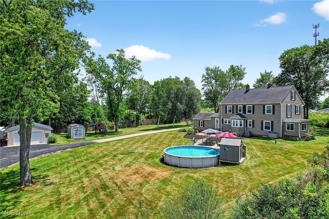3905 Greenwich Rd, Norton, OH 44203 - view of yard featuring a storage unit, an outdoor pool, and view of wooded area