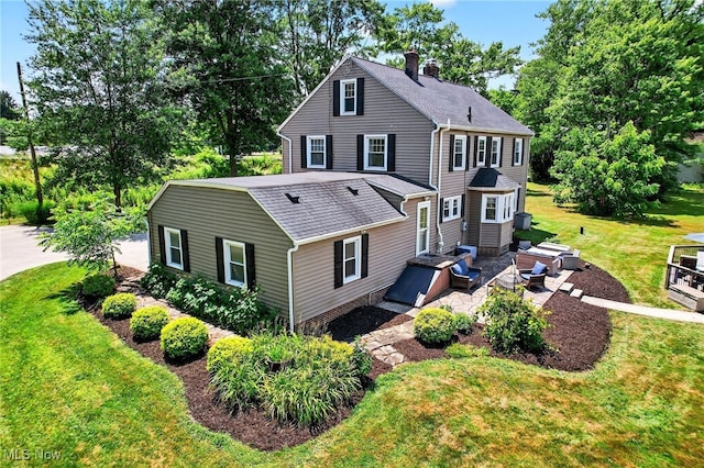 3905 Greenwich Rd, Norton, OH 44203 - back of property with roof with shingles, a lawn, a chimney, and a patio area