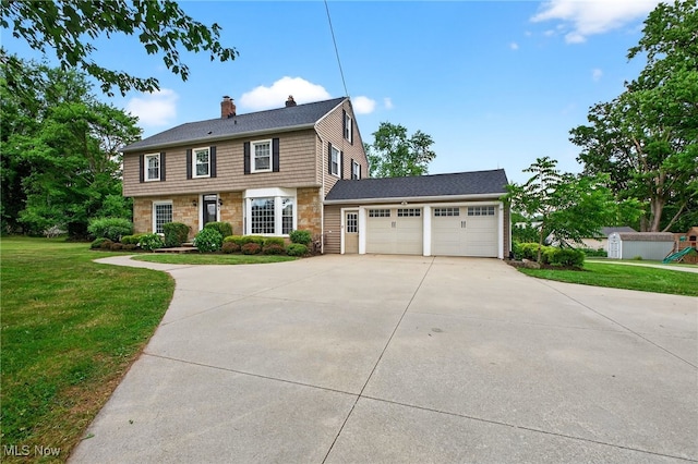 3905 Greenwich Rd, Norton, OH 44203 - colonial house with stone siding, a chimney, concrete driveway, a front yard, and an attached garage