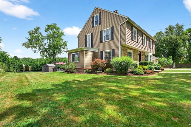 3905 Greenwich Rd, Norton, OH 44203 - view of side of home featuring a storage shed, stone siding, and a lawn