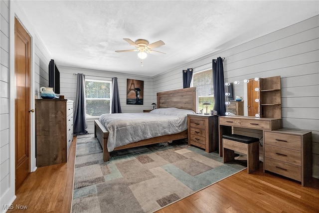 3905 Greenwich Rd, Norton, OH 44203 - bedroom featuring wood finished floors, wood walls, and ceiling fan