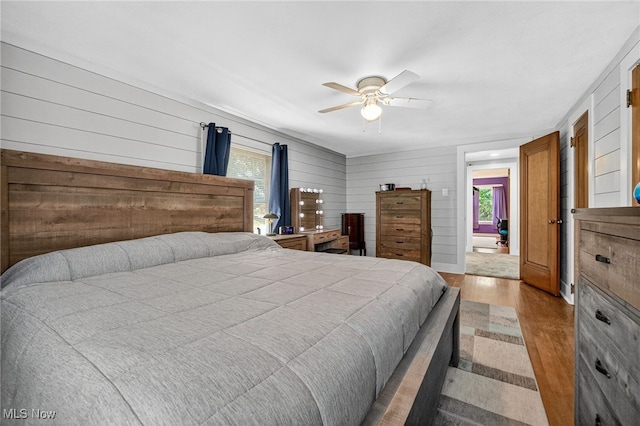 3905 Greenwich Rd, Norton, OH 44203 - bedroom with light wood finished floors, wood walls, and a ceiling fan