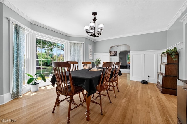 3905 Greenwich Rd, Norton, OH 44203 - dining room featuring arched walkways, a decorative wall, a chandelier, light wood finished floors, and a wainscoted wall