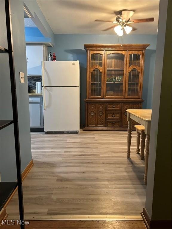 1345 Autumn Dr NW, Warren, OH 44485 - kitchen with freestanding refrigerator, a ceiling fan, light wood finished floors, and glass insert cabinets